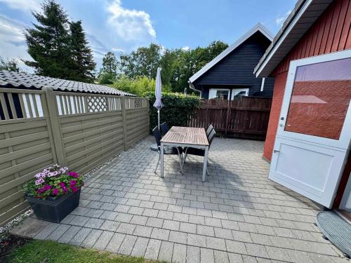 a patio with a table and a fence at Cozy Cottage With A View Of Kerteminde Fjord in Munkebo