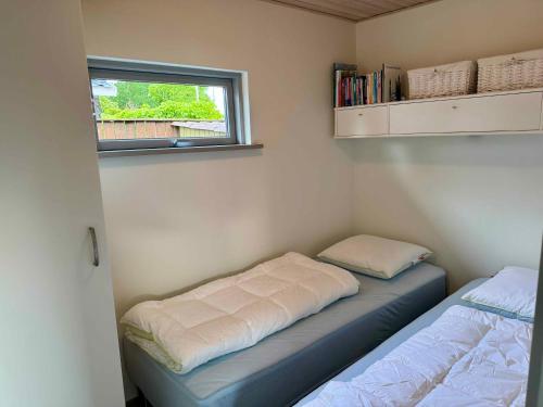 a small room with two beds and a window at Cozy Cottage With A View Of Kerteminde Fjord in Munkebo