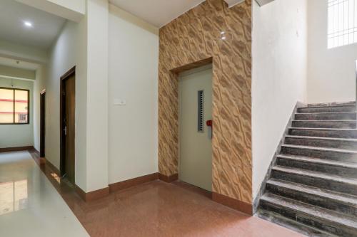 a hallway with a staircase and a wall with a door at Hotel Navya Grand in Patna