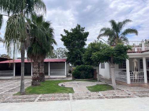 a house with two palm trees in front of it at 3 Marías in Silao