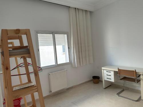 a room with a ladder and a desk and window at Single Room downtown La Marsa- Near the Sea in La Marsa