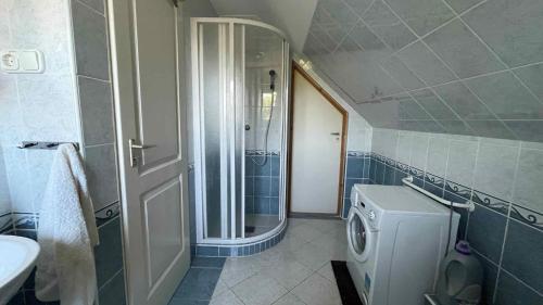 a bathroom with a shower and a washing machine at Holiday home in Balatonmariafürdo 54665 in Balatonmáriafürdő