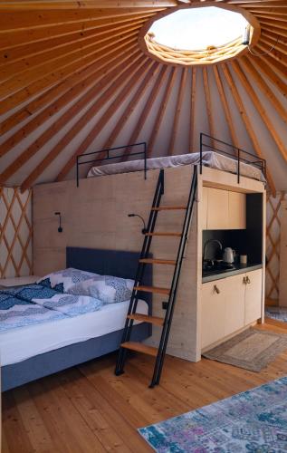 a room in a dome house with a bunk bed and a ladder at Jurty Glamping Moje Taghazout in Lubiatowo