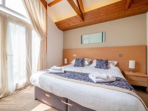 a bedroom with a large bed with towels on it at Haven -79 in Perranwell