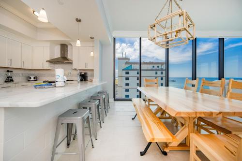 una cucina con un grande tavolo e sedie in legno di Phoenix Gulf Shores II 1005 condo a Gulf Shores