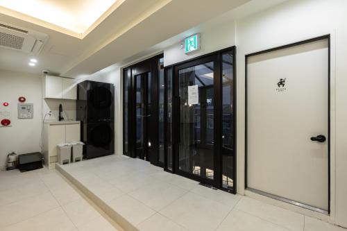 an empty hallway with glass doors in a building at Sleep Box in Seoul