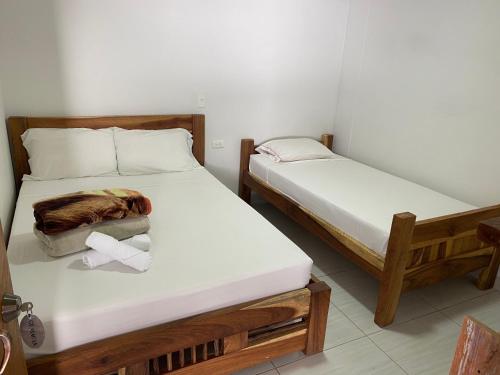 two twin beds in a room with towels on them at HOTEL LA SELVA JARDIN in Jardin