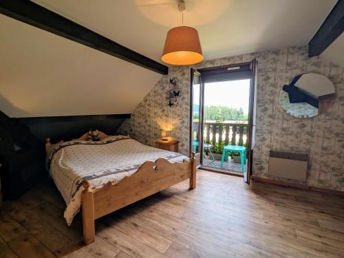 a bedroom with a bed and a large window at Chambre spacieuse avec balcon et accès piscine chauffée - FR-1-589-701 in Anould