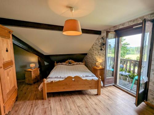 ein Schlafzimmer mit einem Bett und einem großen Fenster in der Unterkunft Chambre familiale avec piscine et SPA à Anould - FR-1-589-708 in Anould