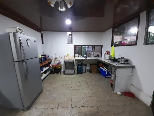 a large kitchen with a refrigerator and a counter at Country house in San Pablo