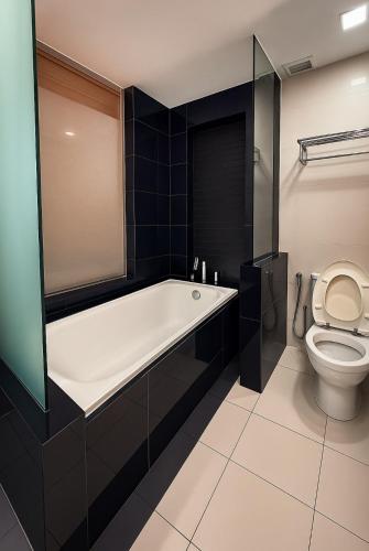 a bathroom with a bath tub and a toilet at KL Sentral Dua Sentral Cozy Homestay Apartments by Hollywood Homes #FreeCarPark in Kuala Lumpur