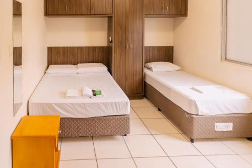 a room with two beds and a table at HANNA Amsterdam Hotel & Eventos in Florianópolis