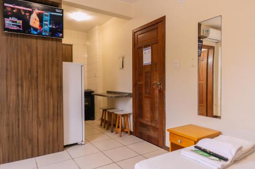 a room with a bed and a tv on the wall at HANNA Amsterdam Hotel & Eventos in Florianópolis