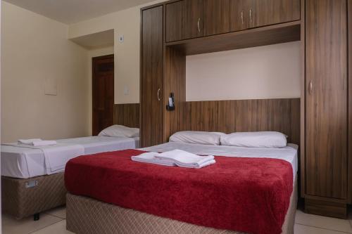 a hotel room with two beds with towels on them at HANNA Amsterdam Hotel & Eventos in Florianópolis