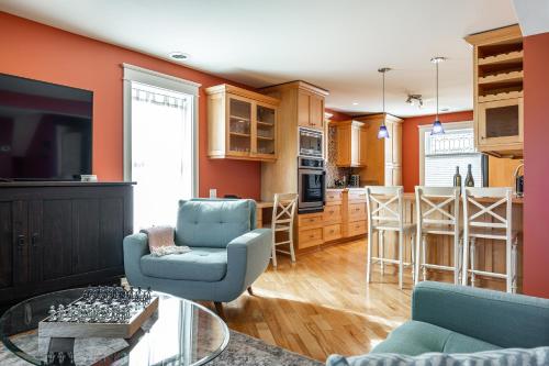 un salon et une cuisine avec des murs orange et des chaises bleues dans l'établissement Glyn Rhosyn Balcony Riverview, à Stratford