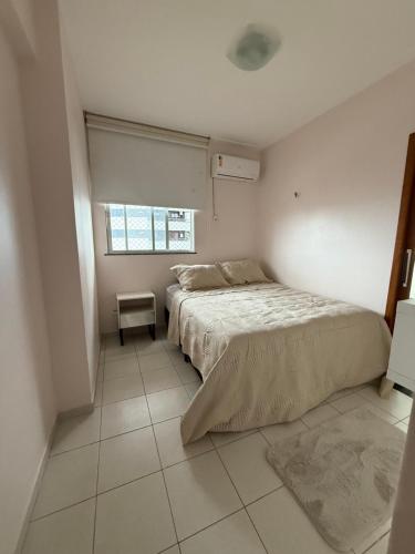 een witte slaapkamer met een bed en een raam bij Apartamento Pedreira in Belém