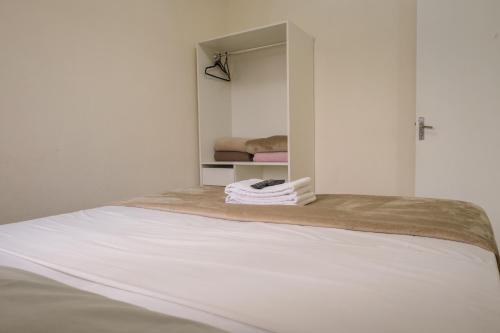 a bed in a white room with a closet at HANNA Amsterdam Hotel & Eventos in Florianópolis