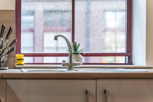 a kitchen sink in front of a window at Leeds Stylish City Flat - Sleeps 8 - 2 mins to City Centre in Central Station