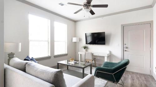 a living room with a couch and a ceiling fan at Landing at The Flats at Shadowglen - Manor in Manor