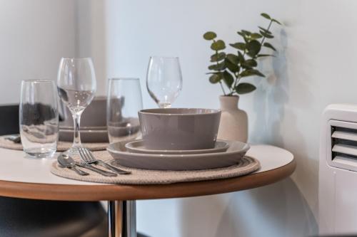 a table with two wine glasses and a bowl on it at Leeds Stylish City Flat - Sleeps 8 - 2 mins to City Centre in Central Station
