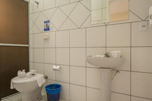 a bathroom with a toilet and a sink at HANNA Amsterdam Hotel & Eventos in Florianópolis
