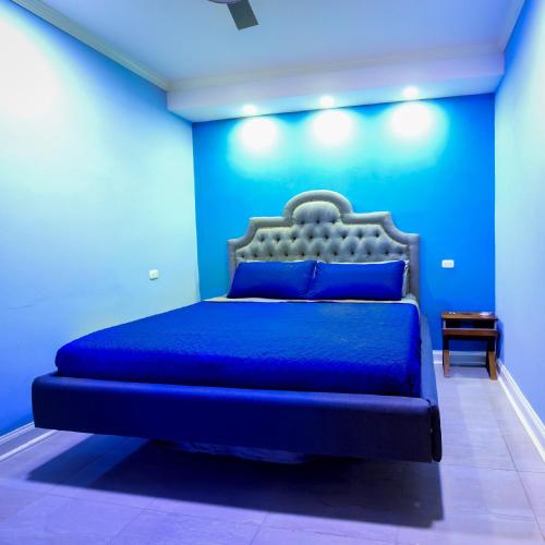 a blue bedroom with a bed with a blue wall at Hotel Bugambilias in Estelí