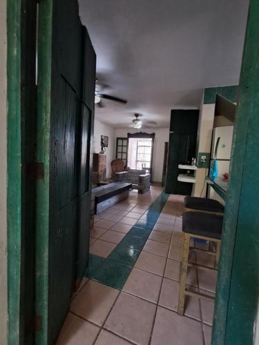 a kitchen with green walls and a room with a table at Driftwood Retreat in Progreso