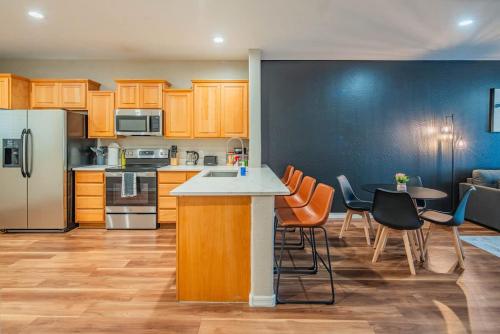 a kitchen with wooden cabinets and a table and chairs at Gym Pool Near ASU Sloan Pk WasherDryer Parking in Tempe