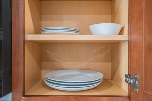 a cabinet with plates and bowls in it at Gym Pool Near ASU Sloan Pk WasherDryer Parking in Tempe