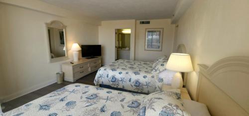 - une petite chambre avec 2 lits et une télévision dans l'établissement Coastal Views Spacious Beachfront Condo, à Daytona Beach