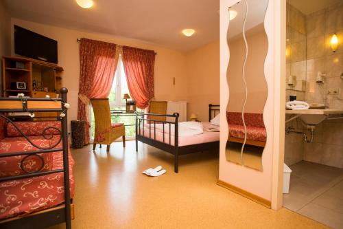 a room with a bedroom with a bed and a bathroom at Mediterran Hotel Juwel in Karlstein am Main