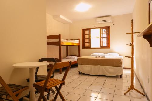 a small room with a bed and a table and chairs at HANNA Amsterdam Hotel & Eventos in Florianópolis