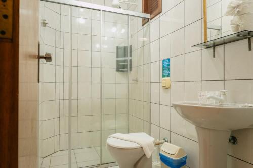 a white bathroom with a toilet and a sink at HANNA Amsterdam Hotel & Eventos in Florianópolis