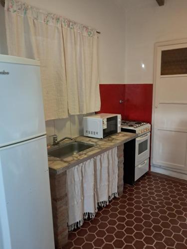 eine Küche mit Spüle und Mikrowelle in der Unterkunft La Casa de María Helenra in Alta Gracia