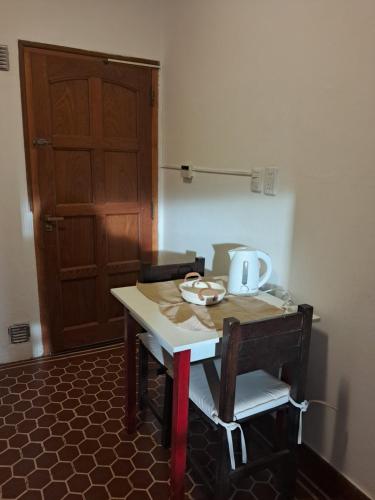ein Tisch und Stühle mit einem Wasserkocher darauf in der Unterkunft La Casa de María Helenra in Alta Gracia