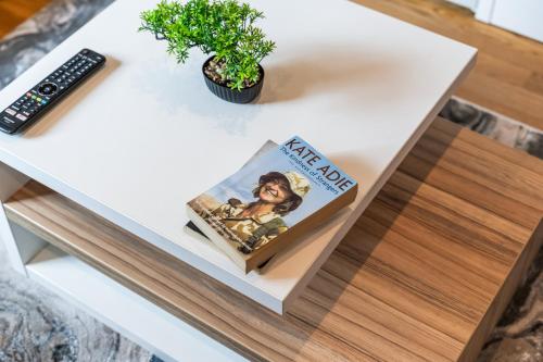 a book on a coffee table with a remote control at Leeds Stylish City Flat - Sleeps 8 - 2 mins to City Centre in Central Station