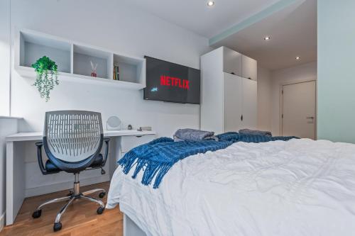 a bedroom with a bed and a desk and a chair at Leeds Stylish City Flat - Sleeps 8 - 2 mins to City Centre in Central Station