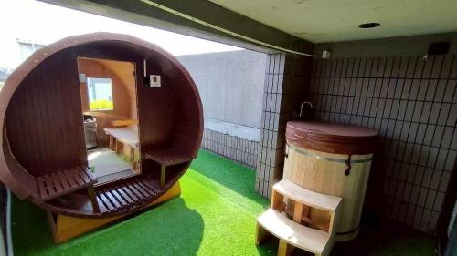 an empty room with a barrel and a room with green grass at BRUCE Luxury House in Izumi-Sano