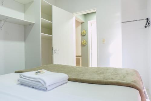 a white room with a bed with a mirror at HANNA Amsterdam Hotel & Eventos in Florianópolis