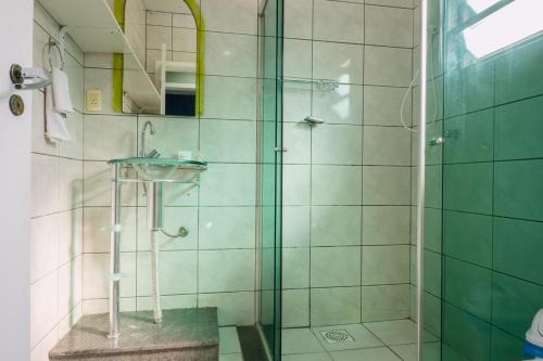 a bathroom with a glass shower with a sink at HANNA Amsterdam Hotel & Eventos in Florianópolis