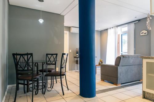 a living room with a table and chairs and a couch at HANNA Amsterdam Hotel & Eventos in Florianópolis
