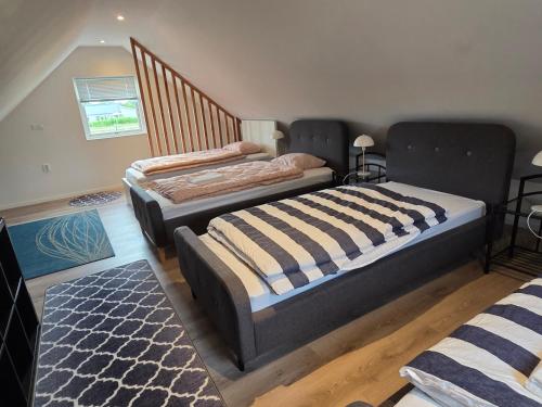 two twin beds in a room with a staircase at Jasmine House in Bromölla