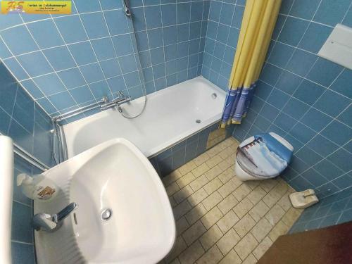 La salle de bains est pourvue de carrelage bleu, de toilettes et d'un lavabo. dans l'établissement Studio in Bad Mitterndorf - Steiermark 37017, à Bad Mitterndorf