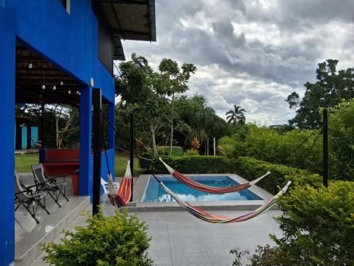 two hammocks on a patio next to a swimming pool at Guacamayo Azul in Iquitos
