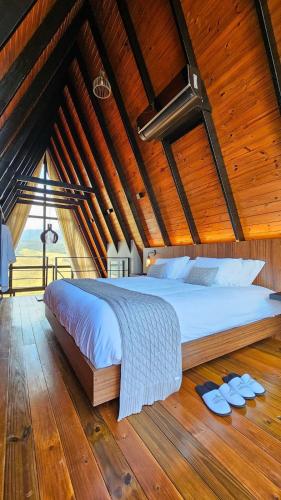 a large bed in a room with a wooden ceiling at Cabana Alecrim in Itanhandu