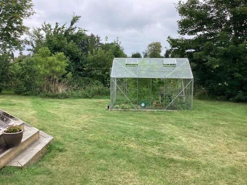 a greenhouse in a field with plants in it at 4 star holiday home in Græsted in Græsted