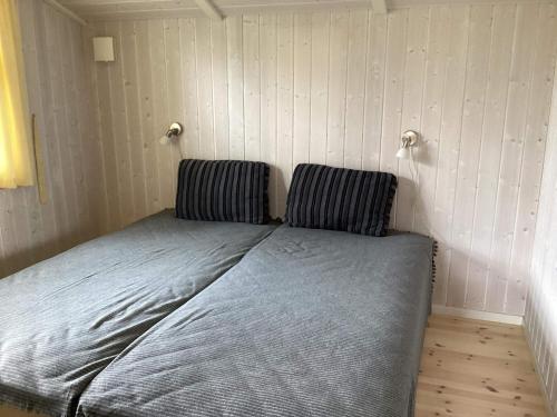 a bed in a room with two pillows on it at 4 star holiday home in Græsted in Græsted