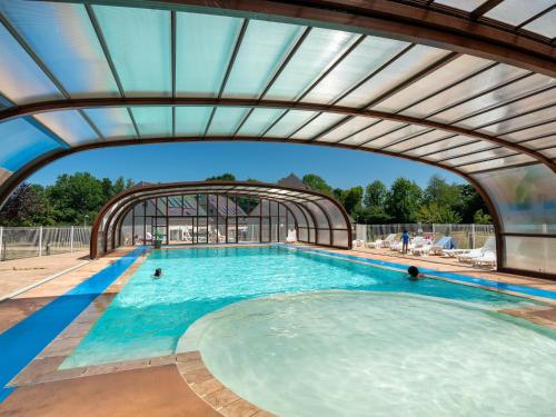 une grande piscine avec un plafond voûté dans l'établissement Neat apartment between Deauville and Cabourg, à Auberville