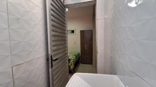 a bathroom with a toilet and a sink and a door at Casa em Stella Maris, 1km da praia - Excelente localização! in Salvador