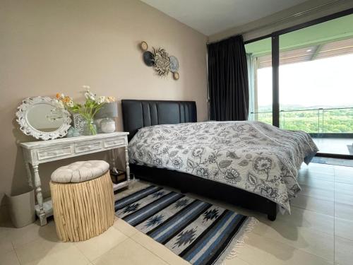 een slaapkamer met een bed, een spiegel en een tafel bij Khaoyai 360 Panoramic View in Ban Tha Chang